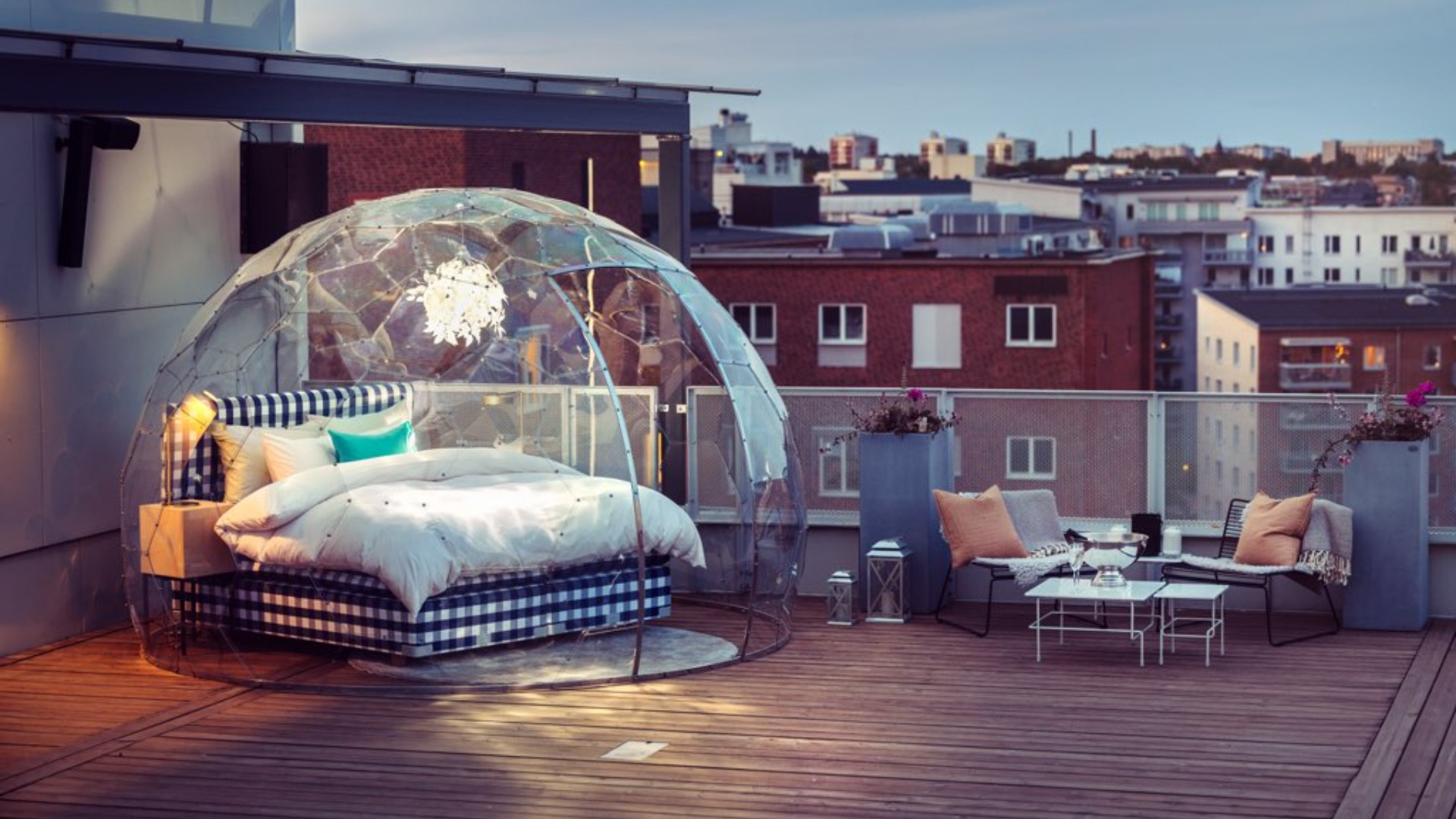 En rutig säng som står på en takterrass i en glaskupa. Fotograf: Avig