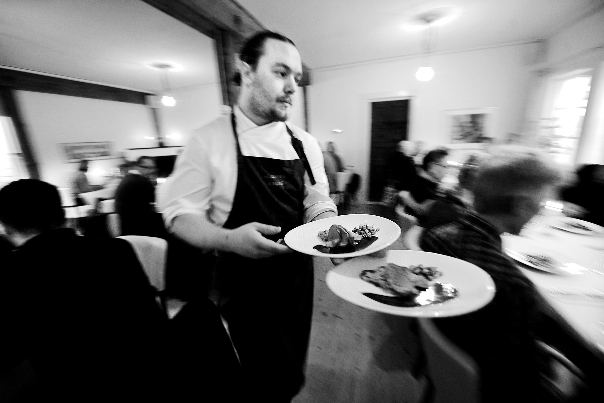 En servitör som bär på två mattallrikar En servitör som bär på två mattallrikar