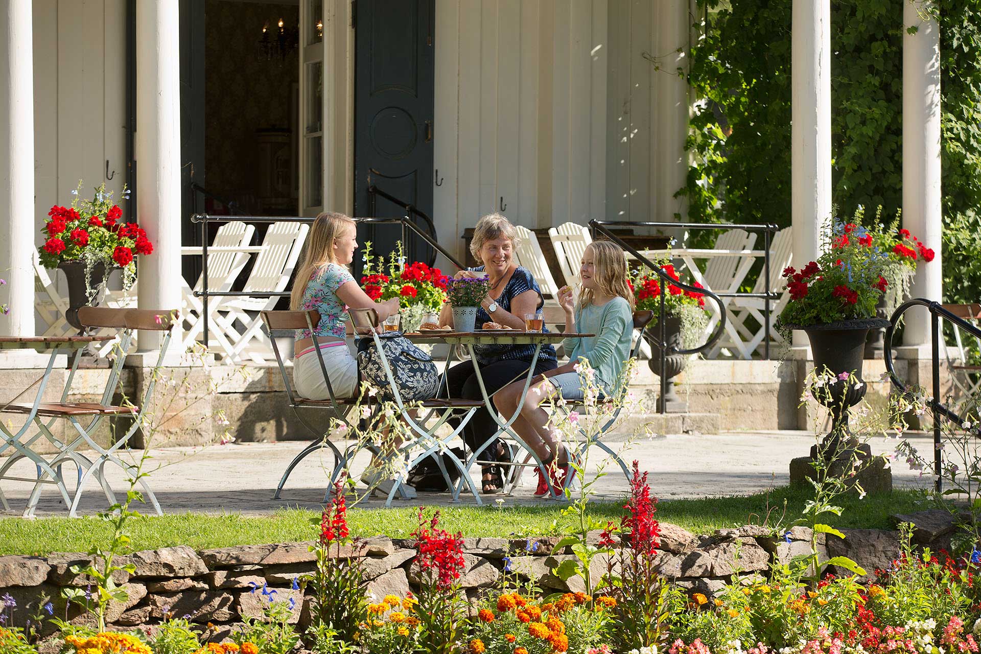 En familj sitter på Alster Herrgård och fikar. En familj sitter på Alster Herrgård och fikar.