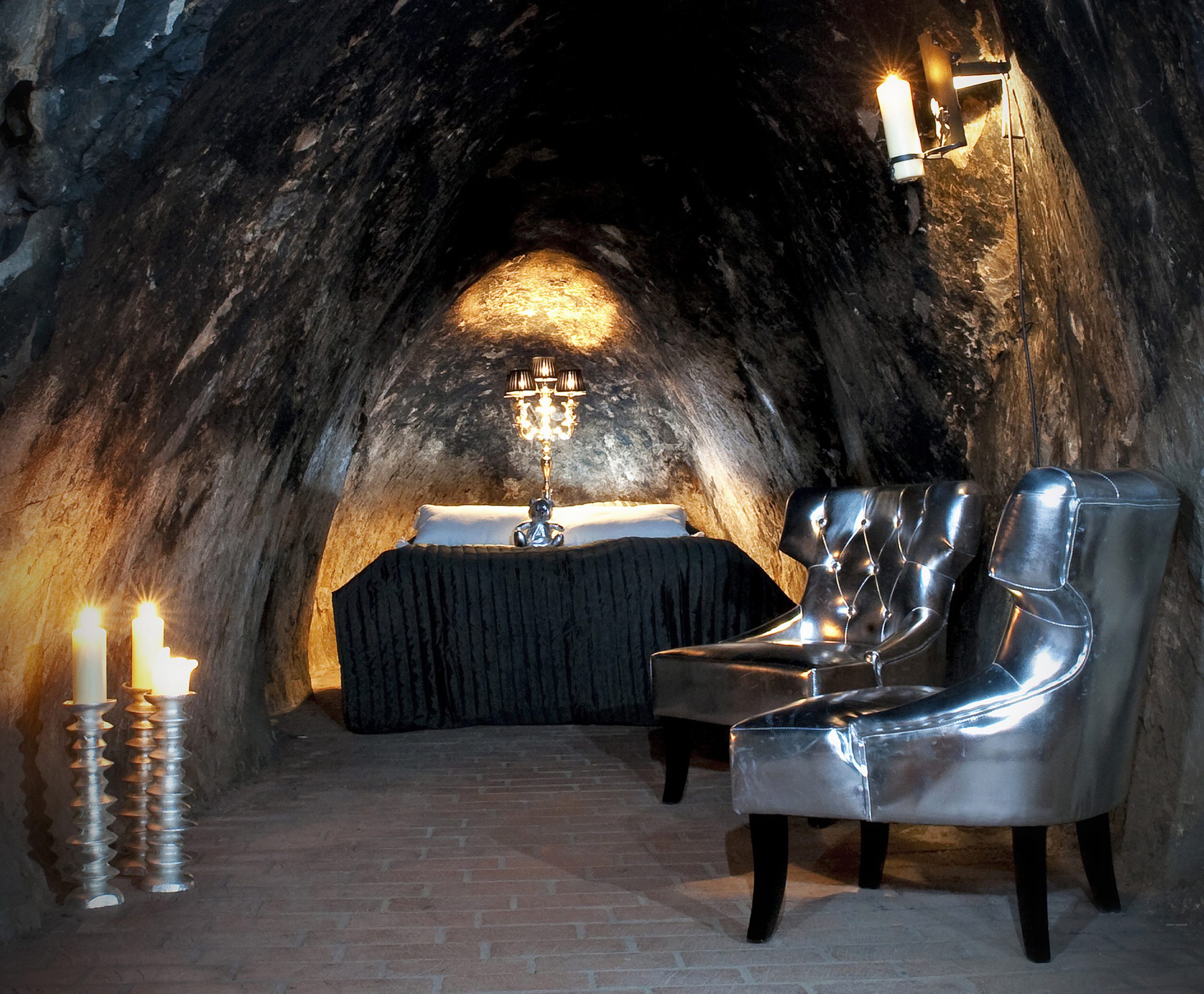 Säng, fåtöljer och ljus i gruvsviten. Foto: Pressbild Sala silvergruva Säng, fåtöljer och ljus i gruvsviten. Foto: Pressbild Sala silvergruva