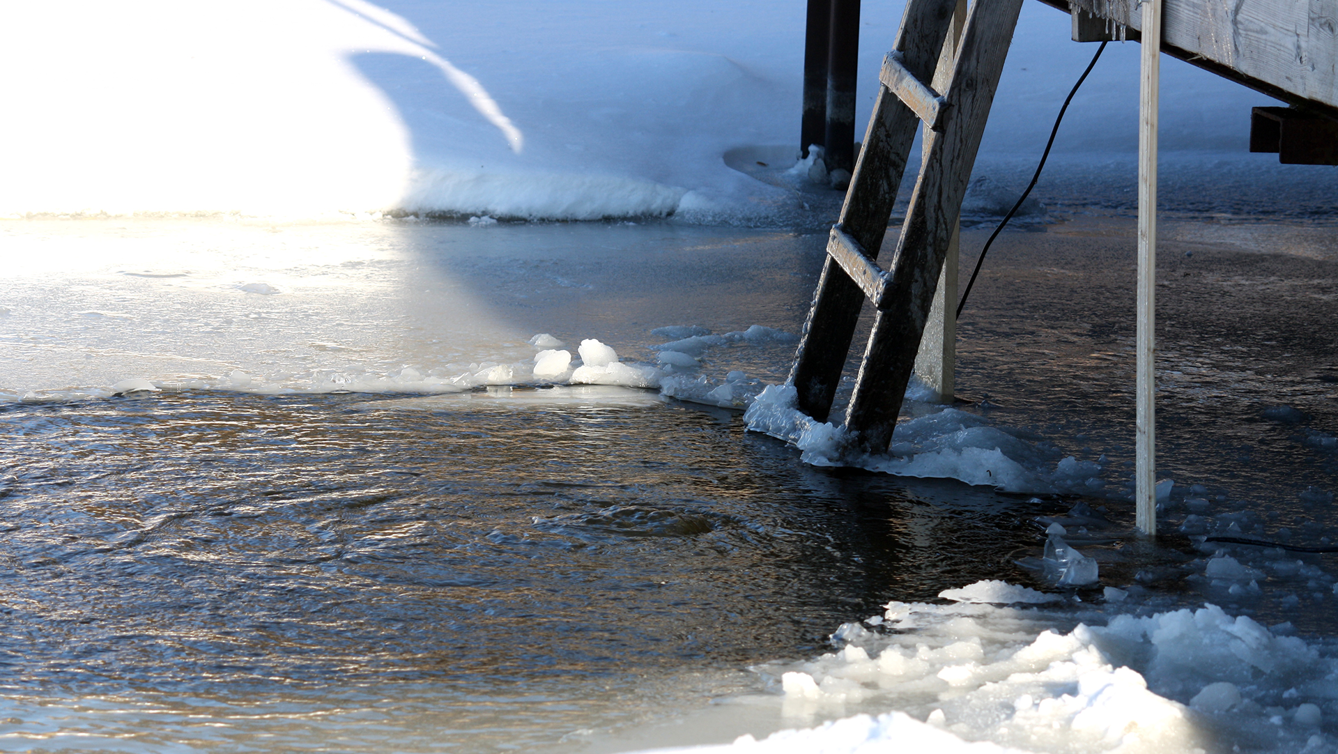 Stege ner i en isvak från en brygga. Foto: Mostphotos
