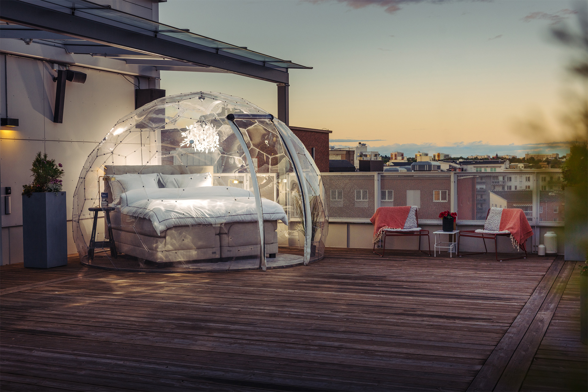 En rutig säng som står på en takterrass i en glaskupa. Fotograf: Avig