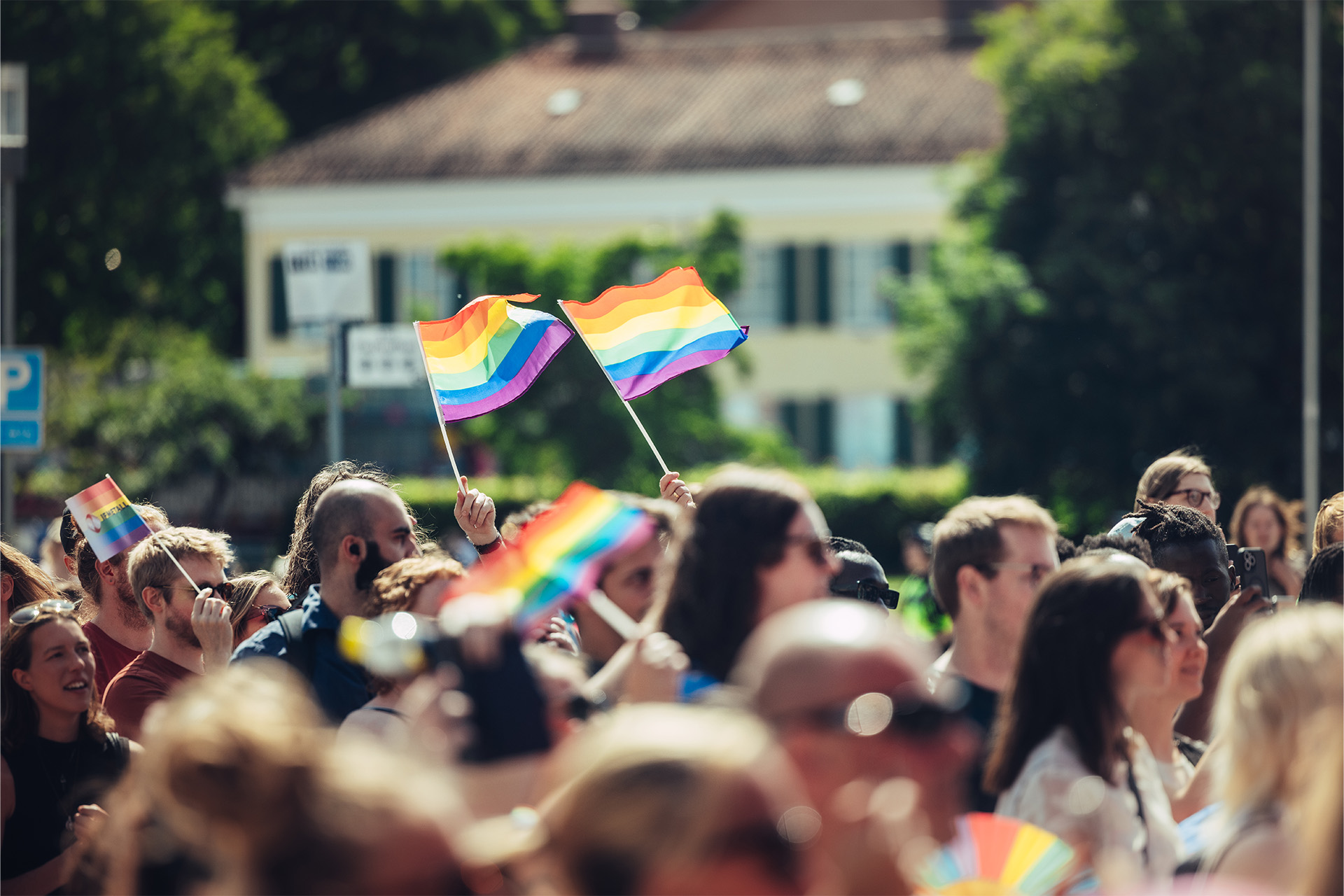 Folkmyller på Västerås Pridefestival och folk viftar med prideflaggan. Foto Avig Kazanjian.