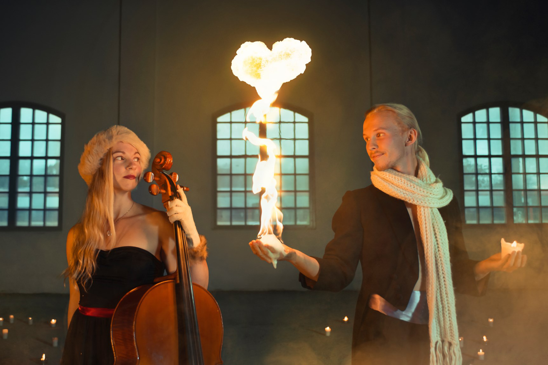 En cellist och en gycklare med ett brinnande hjärta av eld i handen. Foto: Pressbild