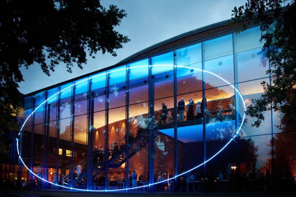 Västerås Konserthus glasfasad med en cirkel i blått neon. Foto: Lasse Fredriksson