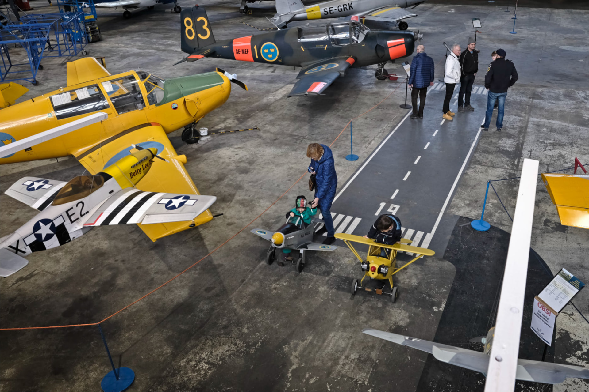 Flygplan i flyghangar och barn som leker i miniflygplan. Foto: Karl-Henry Andersson
