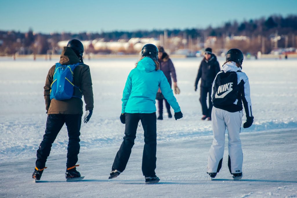 Tre personer som åker skridskor på Mälaren