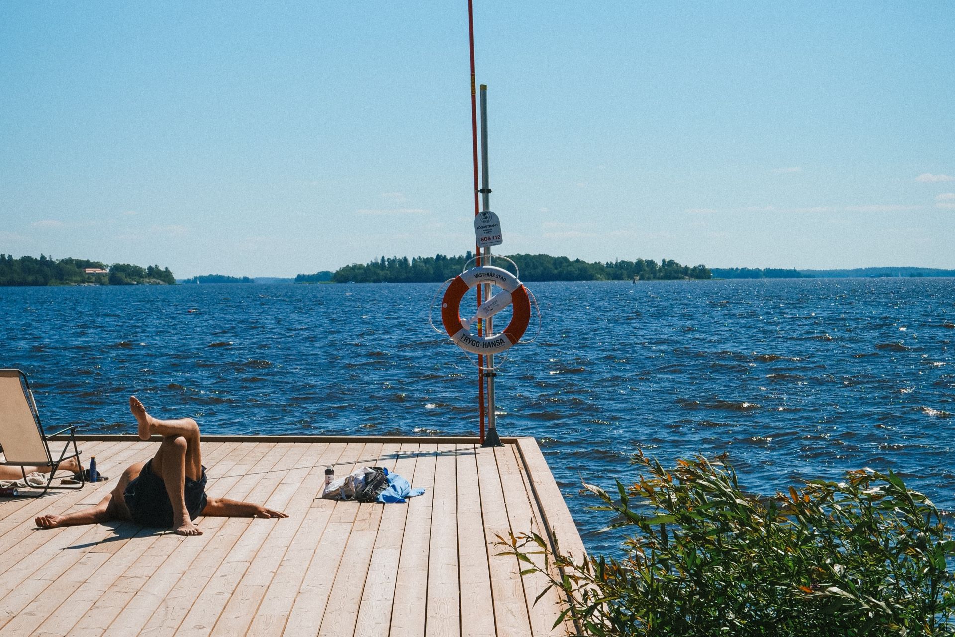 En man som ligger på en brygga vid Mälaren en solig dag En man som ligger på en brygga vid Mälaren en solig dag