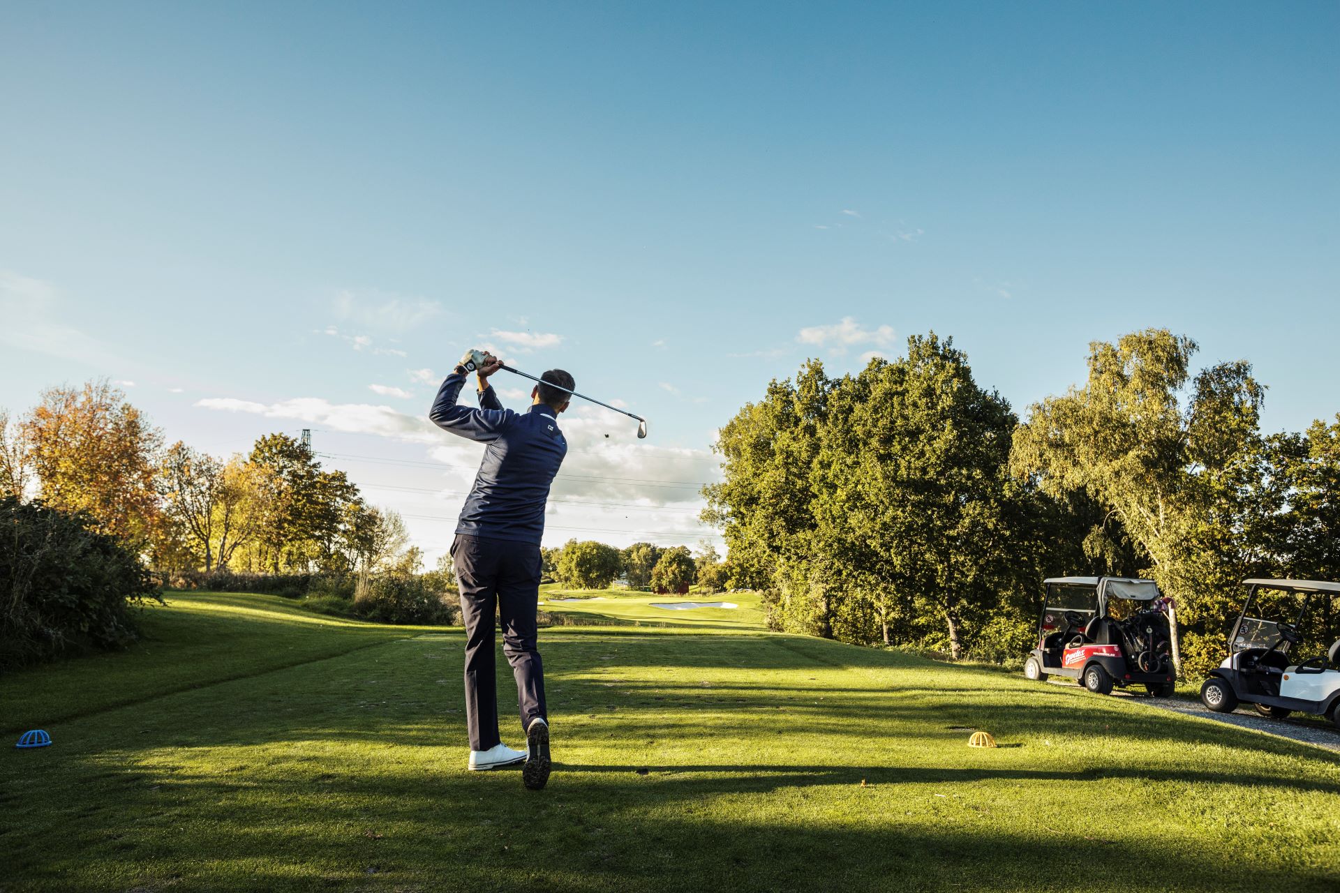 En man som svingar en golfklubba på Västerås GK