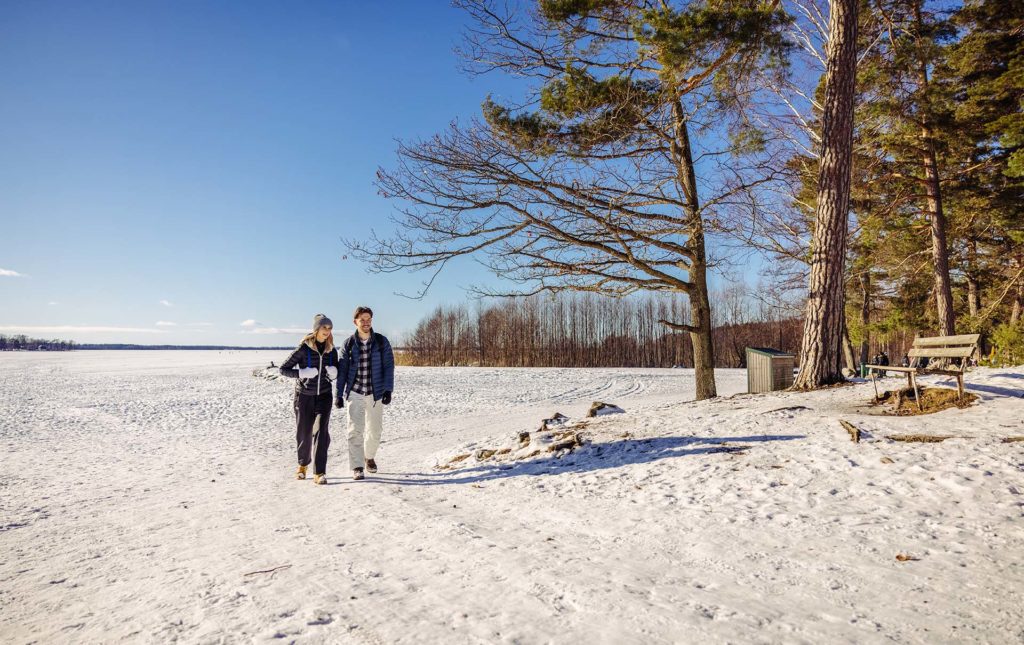 Man och kvinna vandrar i snövintrigt landskap.