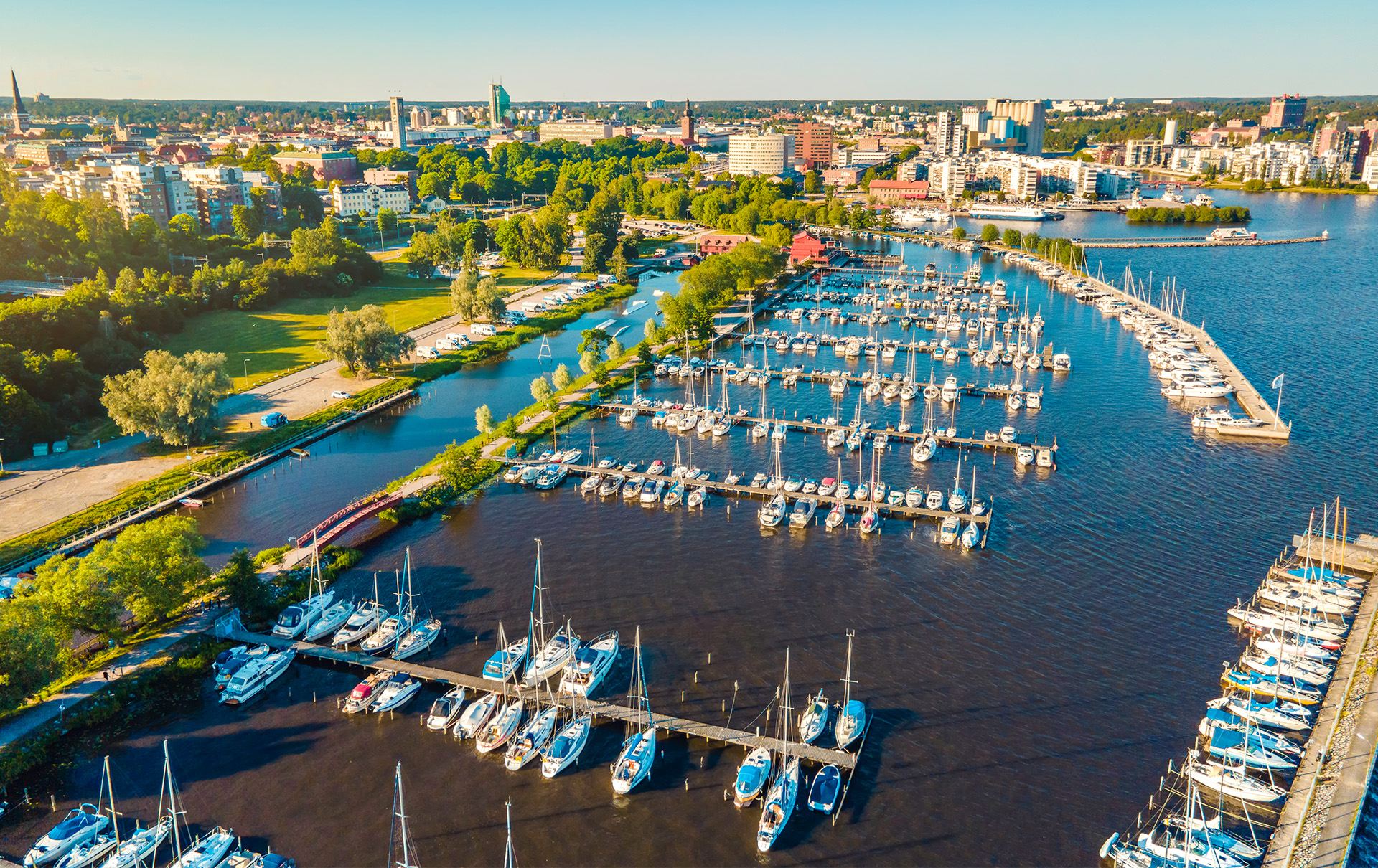 Flygvy över Lögarängen med småbåtshamnen i förgrund och Västerås citys siluett i bakgrunden. Foto: Avig Kazanjian