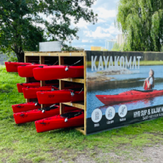 Kayakomat Notuddsparken, en uppställning med röda kajaker för uthyrning