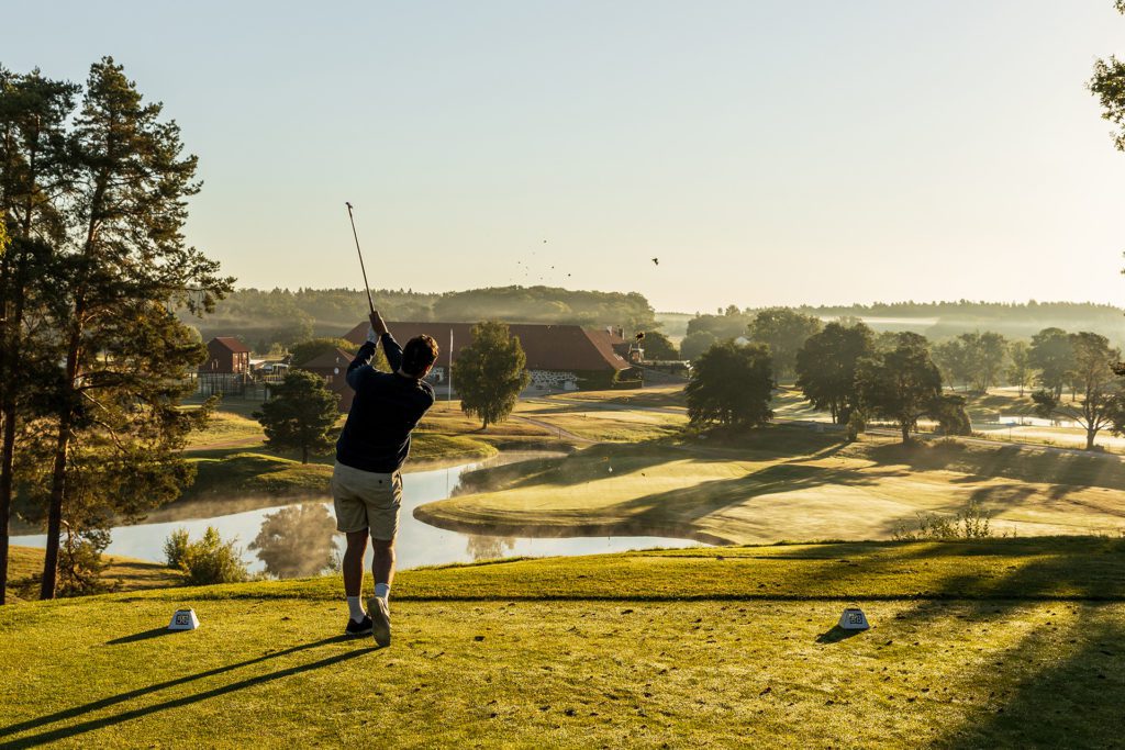 En golfspelare slår ut på ett av Sveriges vackraste korthål. Foto: Henrik Mill