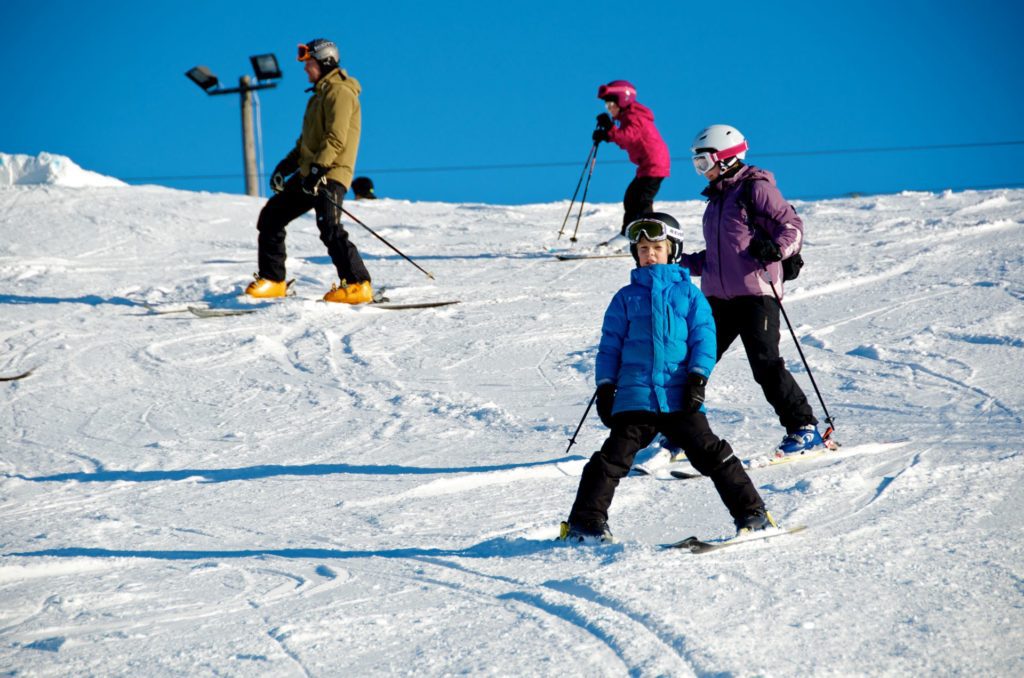 Fyra personer som åker skidor i en backe.