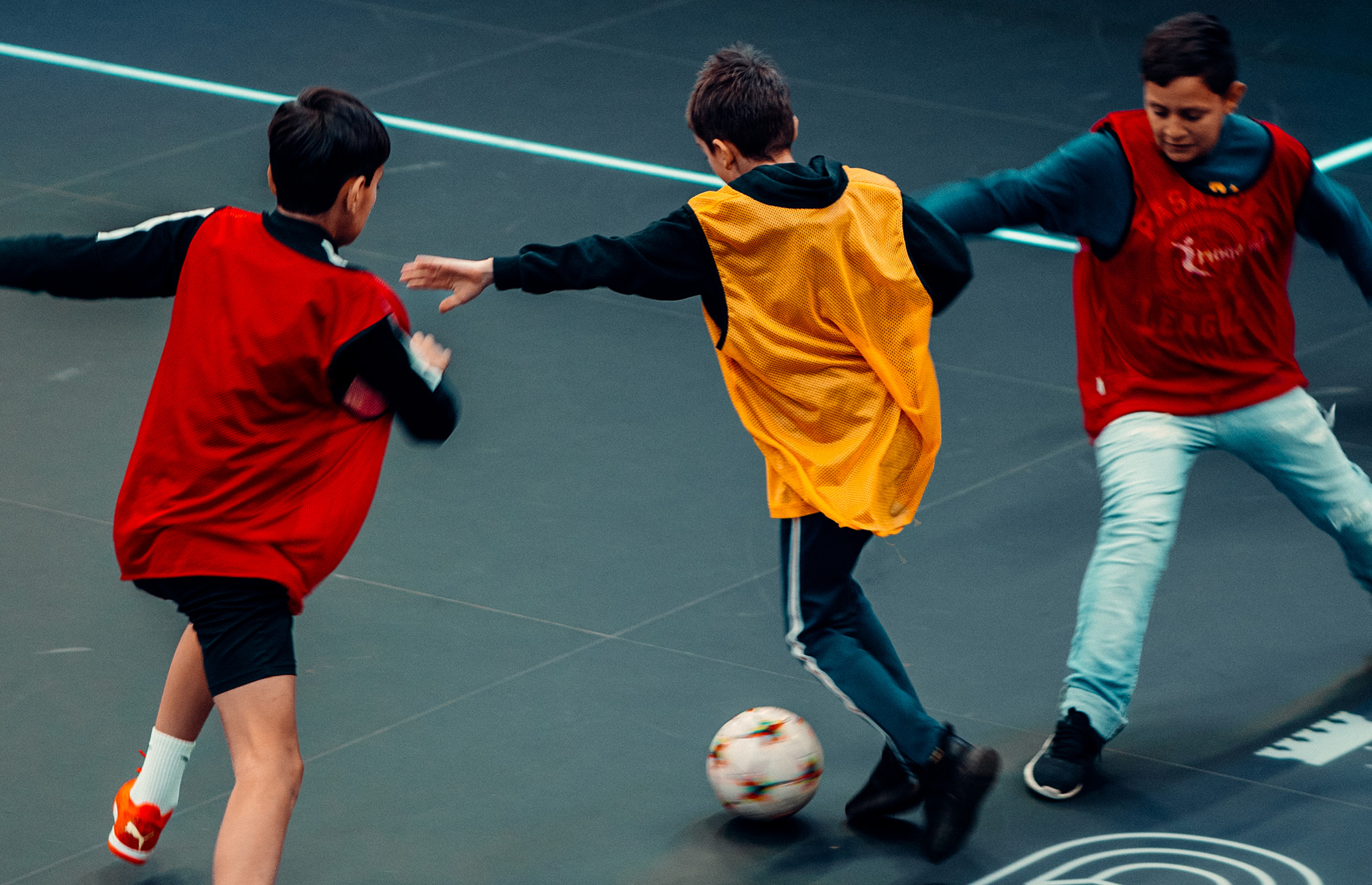 Tre barn spelar fotboll på evenemanget FUZED Summer games Tre barn spelar fotboll på evenemanget FUZED Summer games