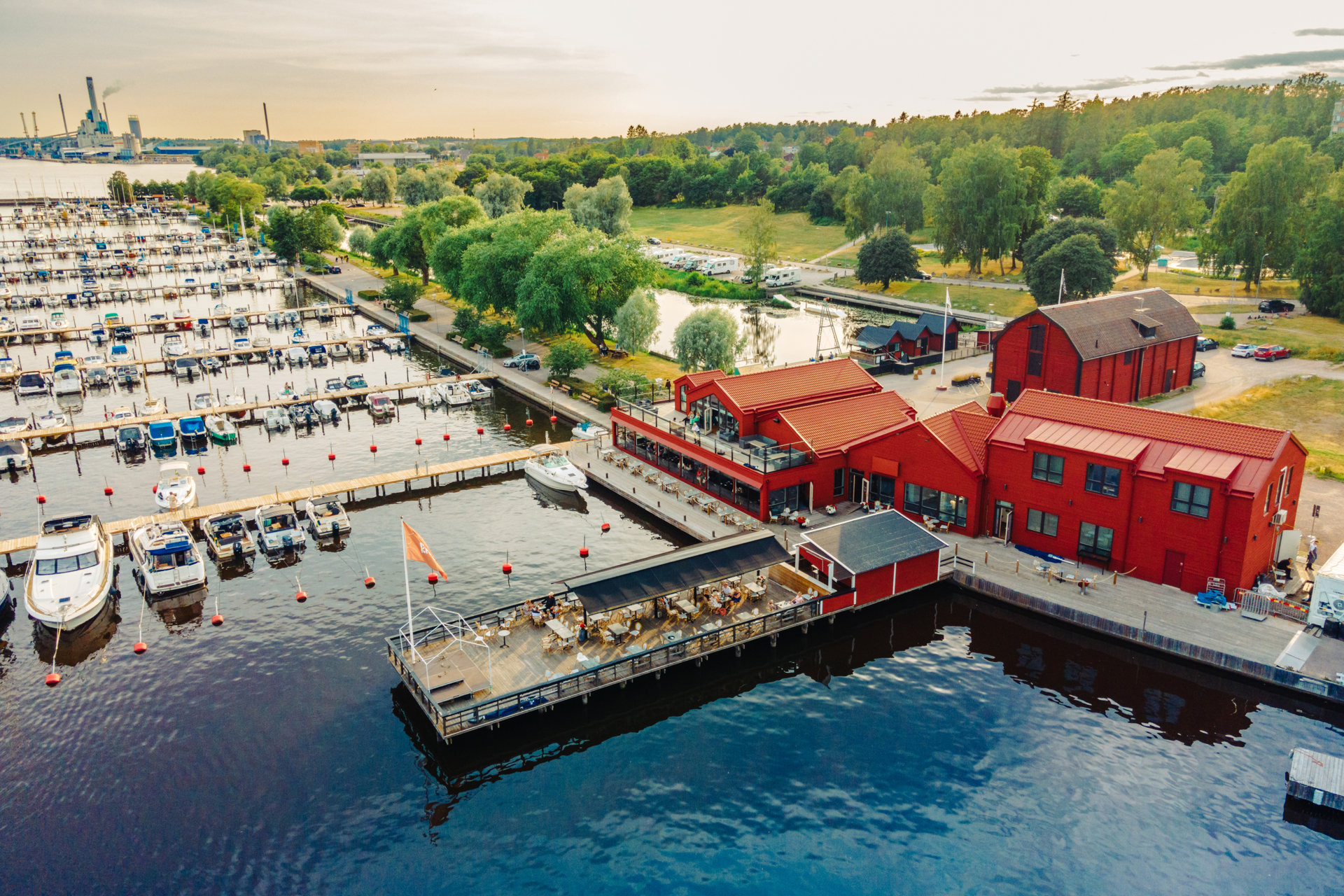 Drönar vy över restaurangbyggnad vid bryggorna i gästhamnen.