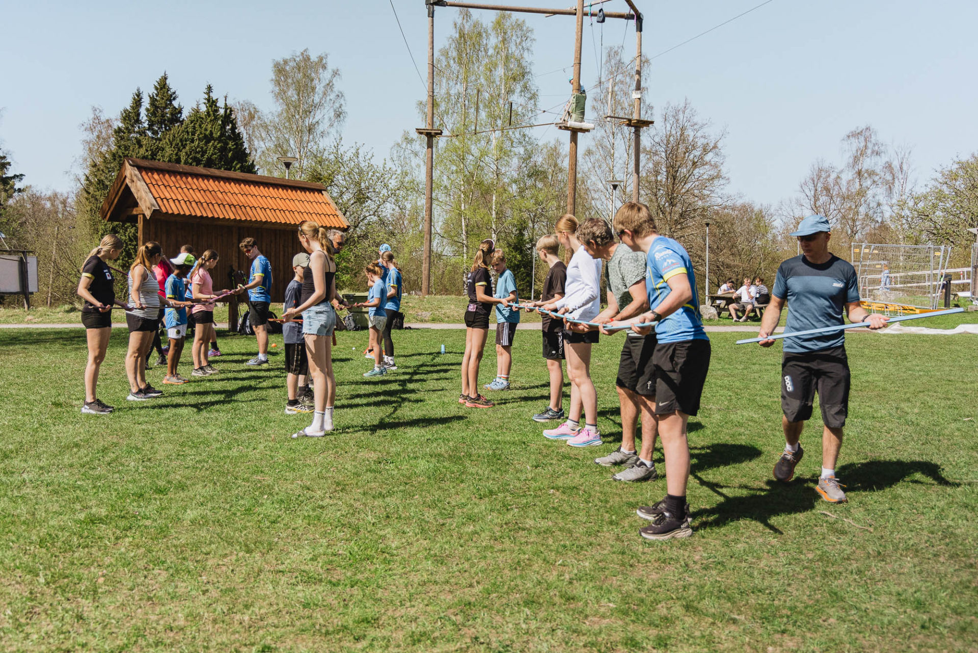 Två grupper människor samarbetar i en teambuilding-aktivitet på en gräsplan