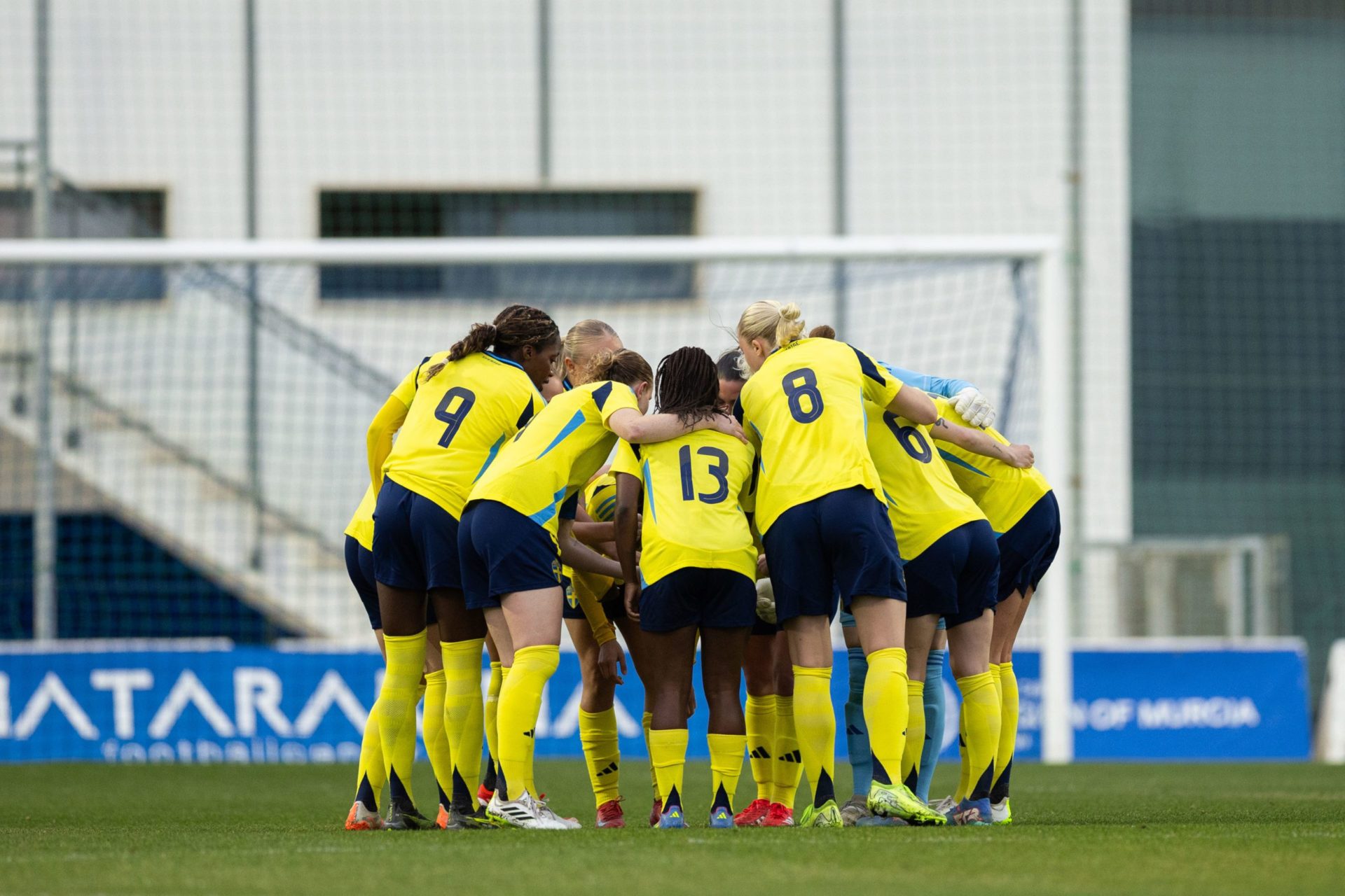 U23 landslaget i fotboll håller om varandra på en fotbollsplan