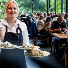 En servitris som serverar mat på Konserthusbistrons restaurang.