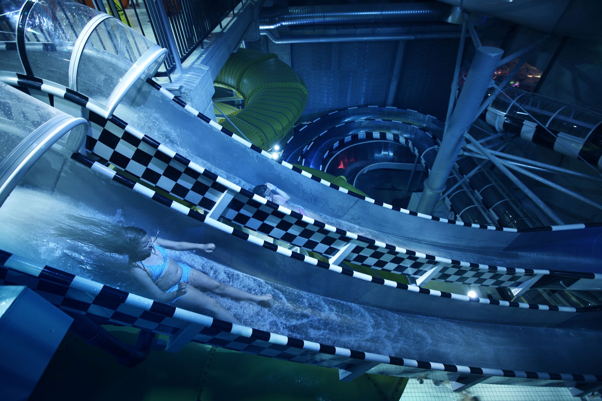 Två personer som tävlar i en vattenrutschkana på Kokpunkten Actionbad