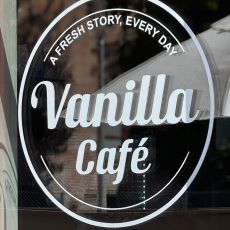 Fönster med vit text där det står Vanilla Café, A fresh story, every day.