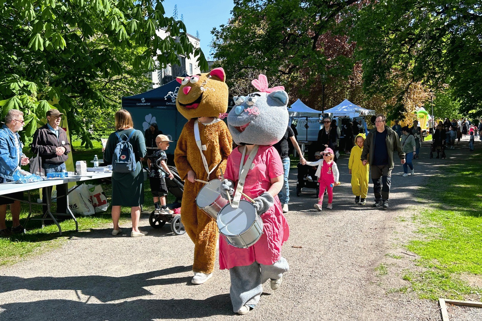 Två maskotar går längst fram i en parad på Västerås barnfestival