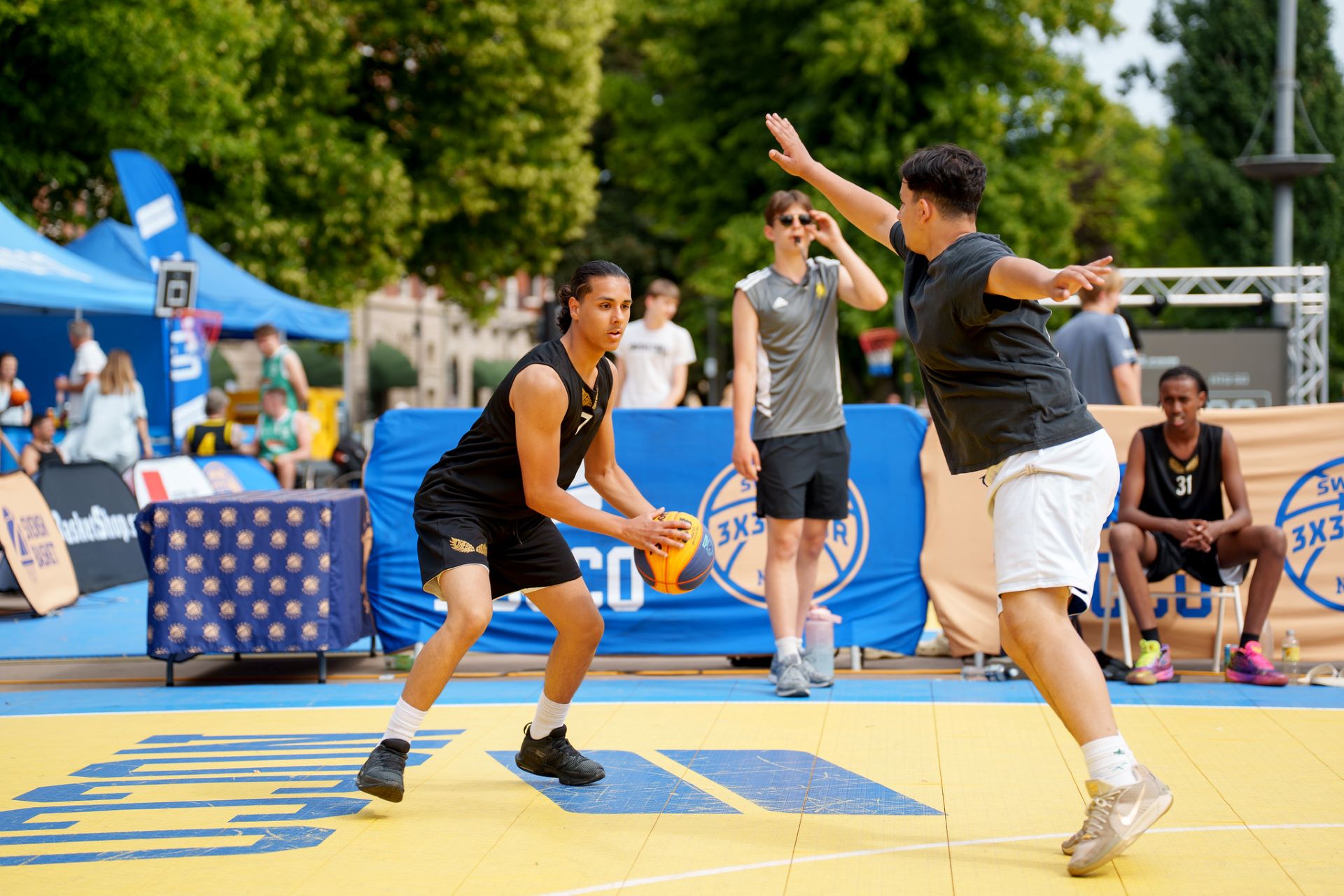 Två killar som spelar basket utomhus