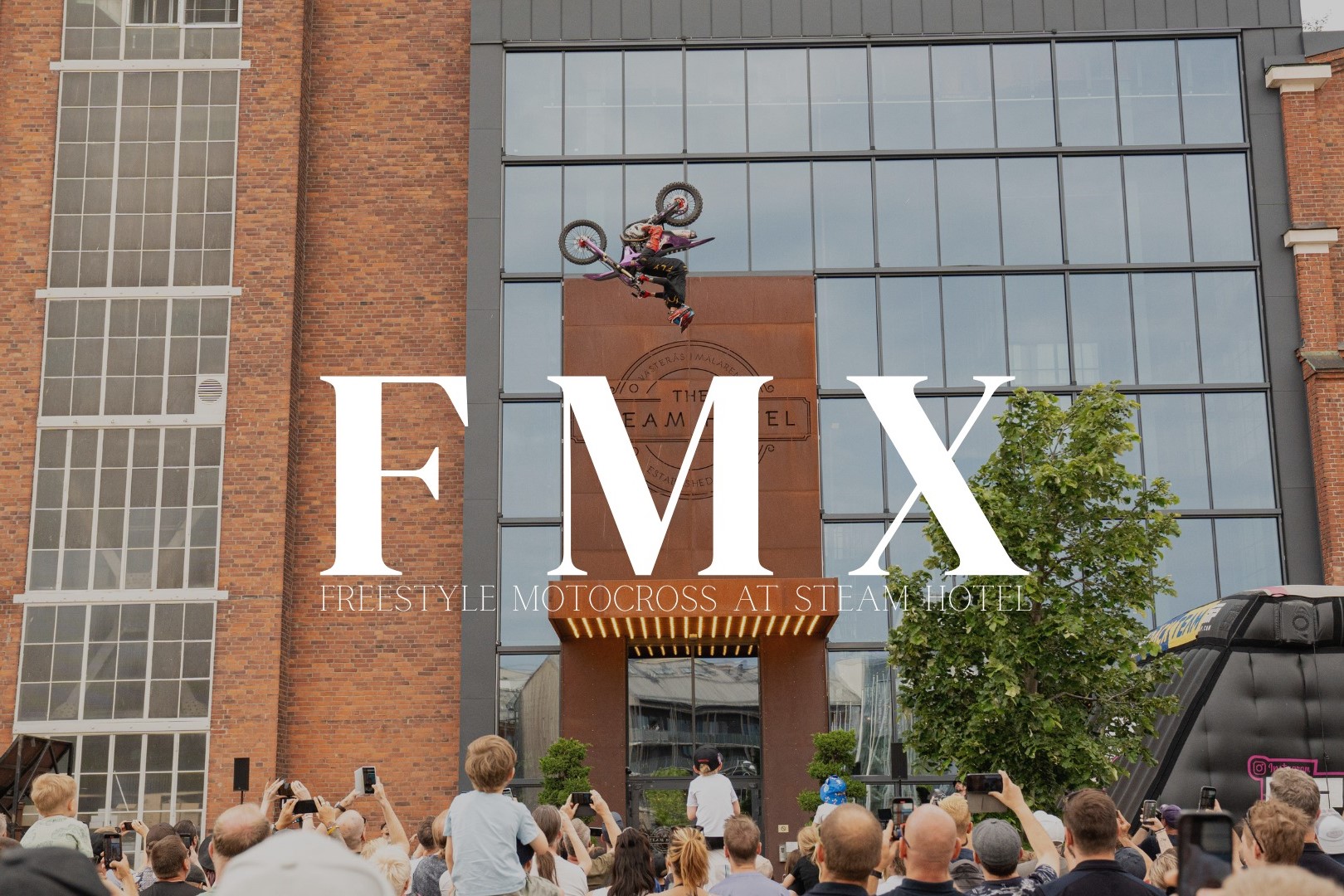 En motocross som gär en volt framför huvudentrén till Steam Hotell.