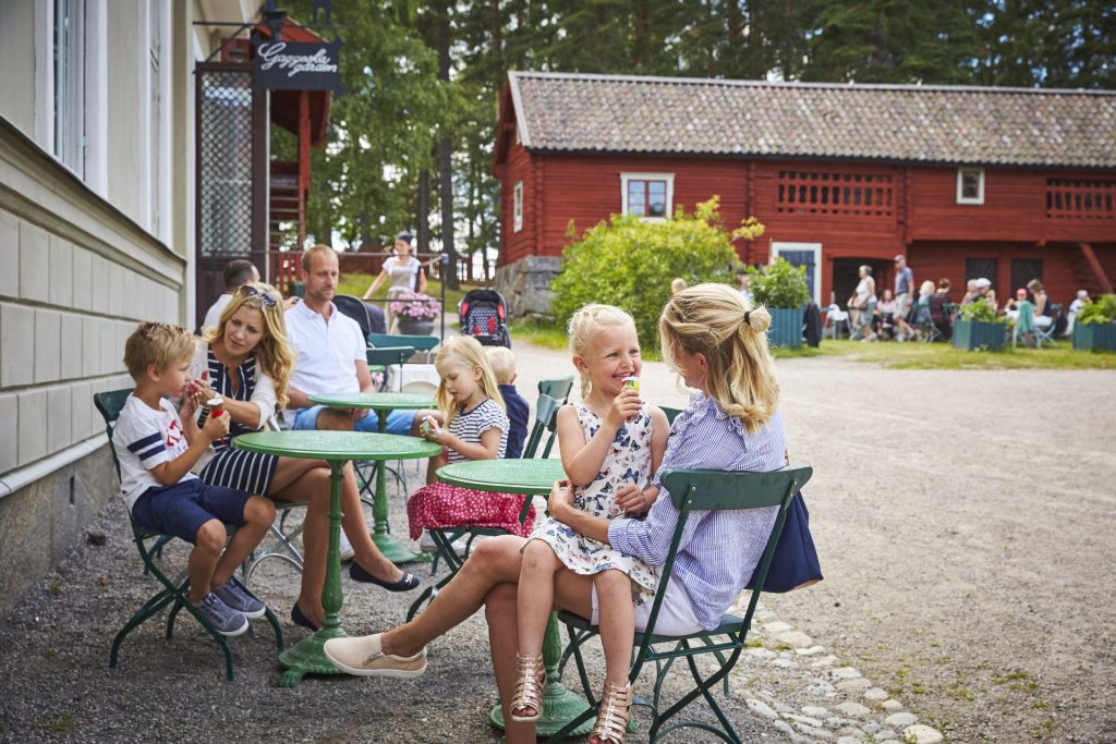 En barnfamilj som sitter och fikar utanför Systrarna på Gaggeska Gården.
