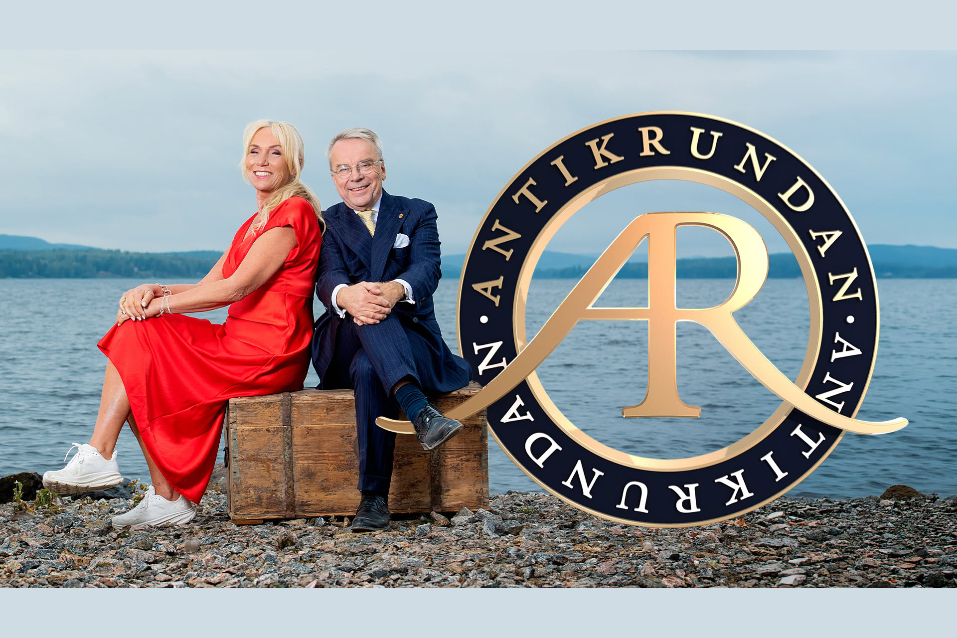 PR-bild för TV-programmet Antikrundan som föreställer en kvinnlig och en manlig programledare som sitter på en låda bredvid logotypen.